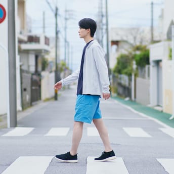 横断歩道を渡る夏服を着た男性の写真