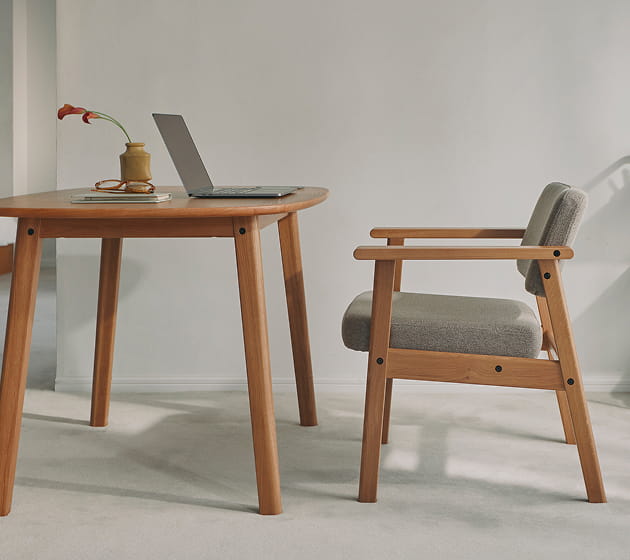 高さが変えられる木製テーブルと木製アームチェアをワークスペースで使用しているイメージ1