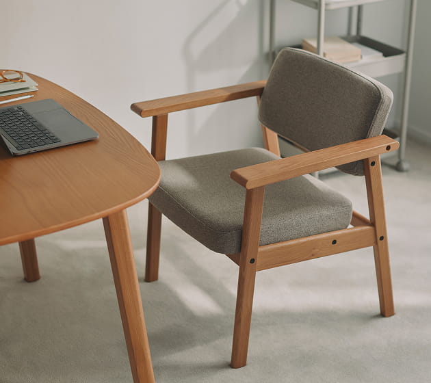 高さが変えられる木製テーブルと木製アームチェアをワークスペースで使用しているイメージ2