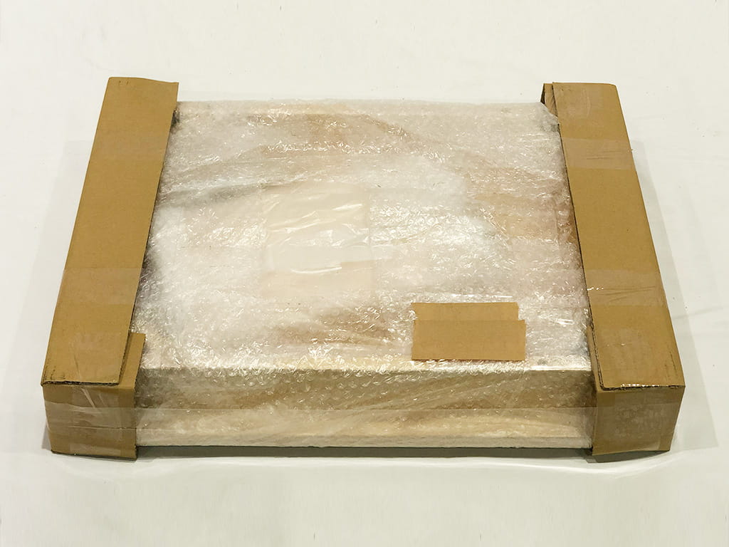 一番外側のダンボールがなくなってしまったプチプチとダンボールに包まれた梱包物の写真