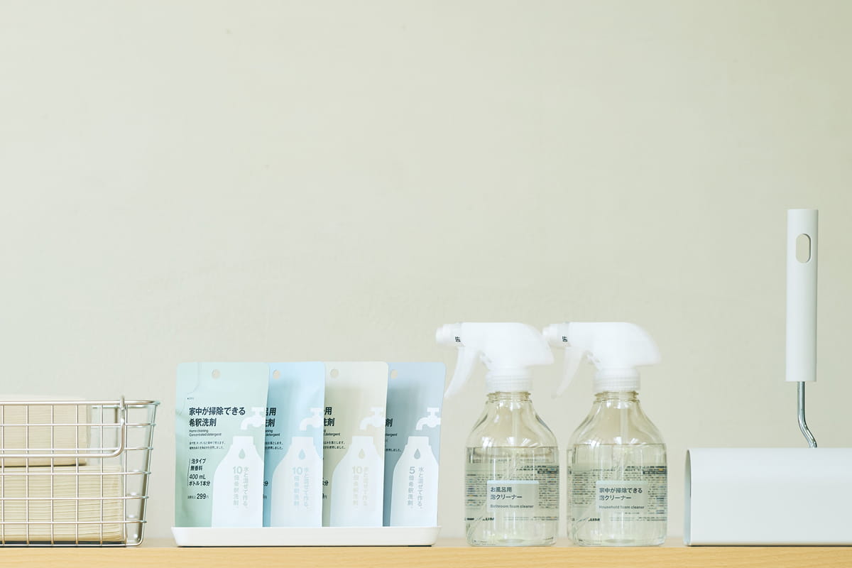 他の掃除用品と並べて収納してある希釈洗剤のボトルとパウチの写真
