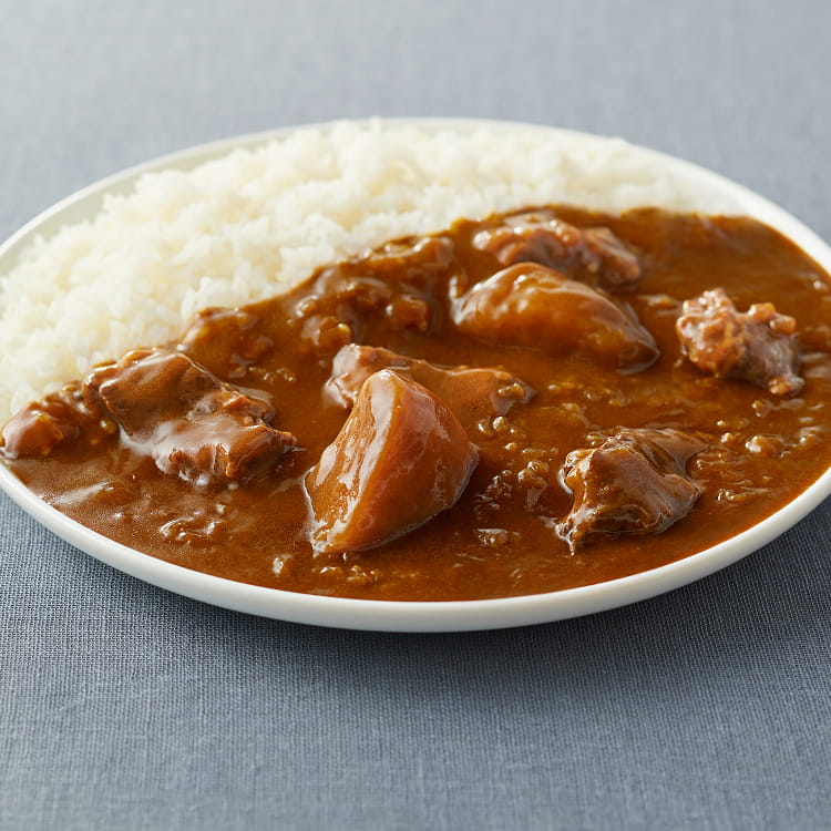 器によそった牛肉と香味野菜の大盛りカレーの写真