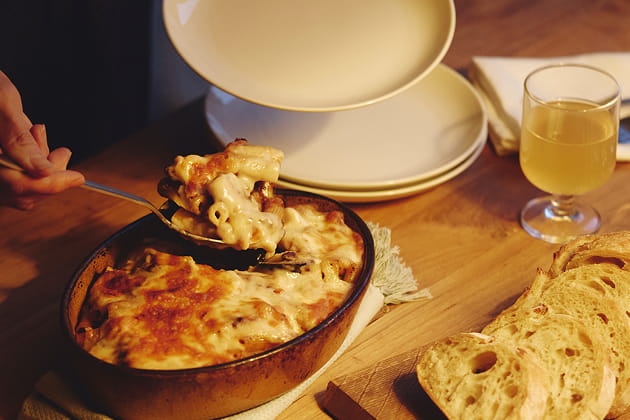 ミートグラタンをスプーンでお皿に取り分けている写真