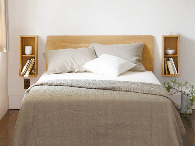 壁に付けられる家具箱をベッドサイドの小物置き場として使う様子。