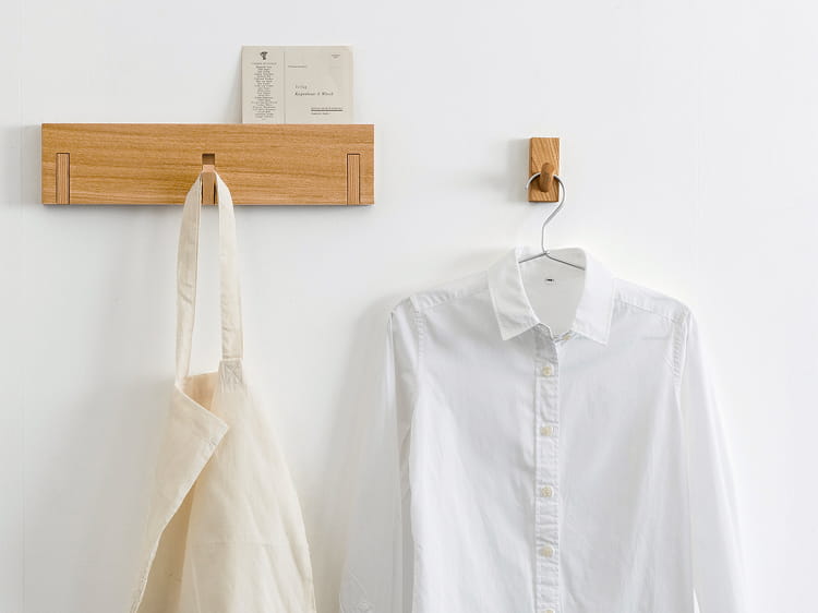 壁に付けられる家具3連ハンガーにバッグを、フックにシャツをかけて使う様子。