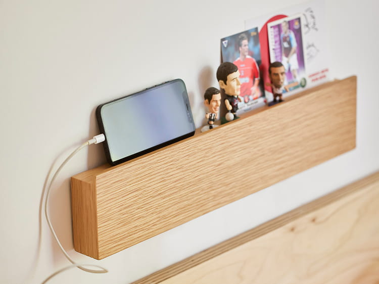 壁に付けられる家具長押にスマホやフィギュアを置いて使う様子。