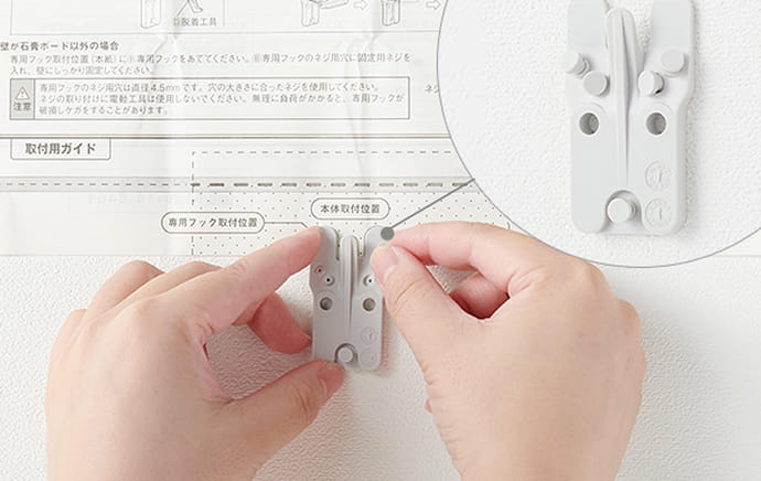 取り付けガイドに沿って専用フックを取り付ける様子