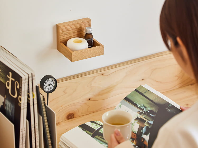 壁に付けられる家具トレーにアロマオイルを置いて使う様子。