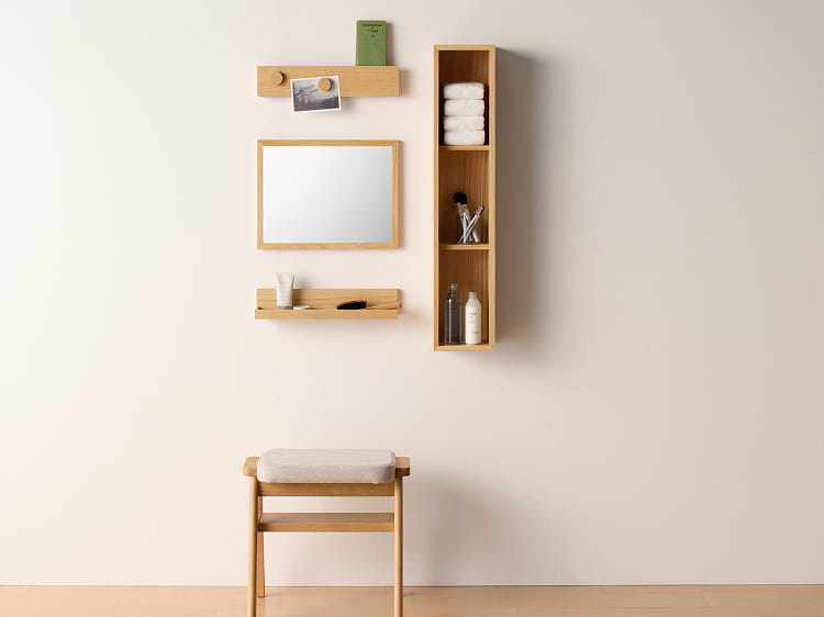 壁に付けられる家具トレーを鏡や箱などと組み合わせてドレッサーとして使う様子。