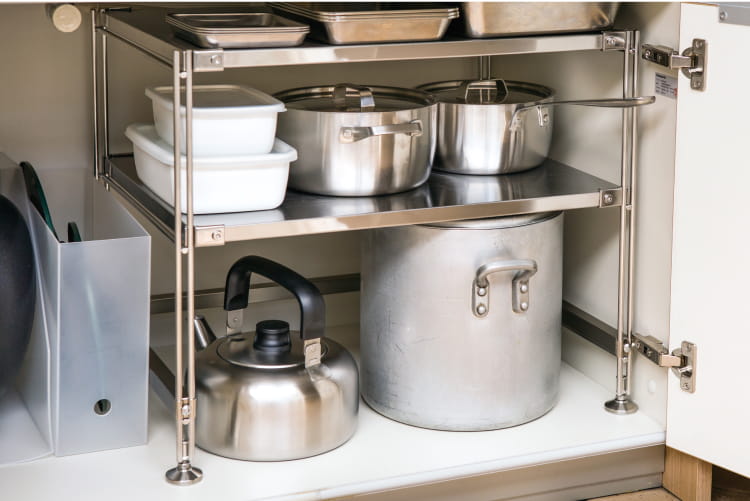 キッチンのシンク下の扉に調理器具が収納されているイメージ
