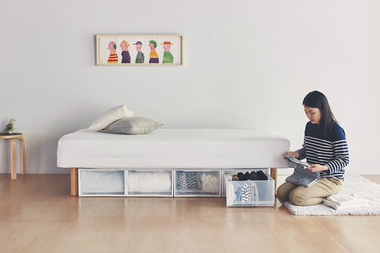 脚付マットレス　ポケットコイル（洗えるカバー　組み立て仕様）シングルサイズの横で洗濯物を畳んでいる人のイメージ