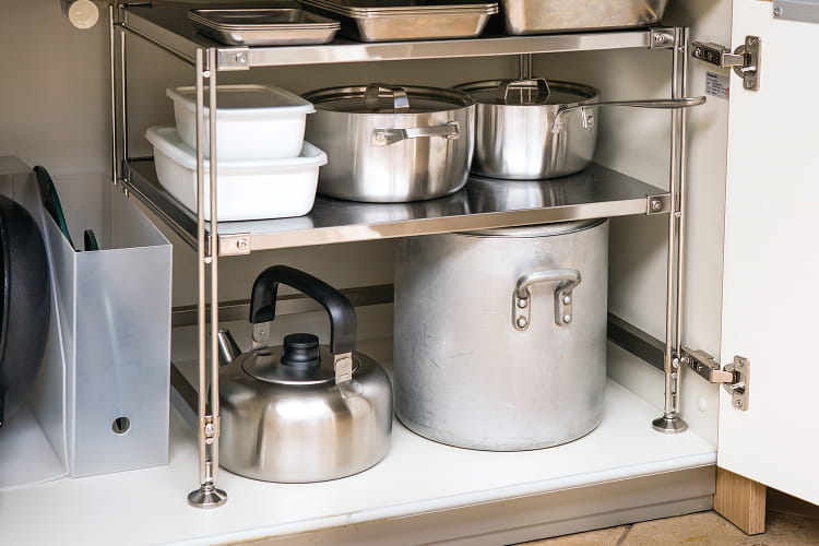 キッチンのシンク下の扉に調理器具が収納されているイメージ