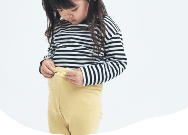 女の子がおなかすっぽりストレッチ十分丈レギンスをひとりでお着替えするイメージ