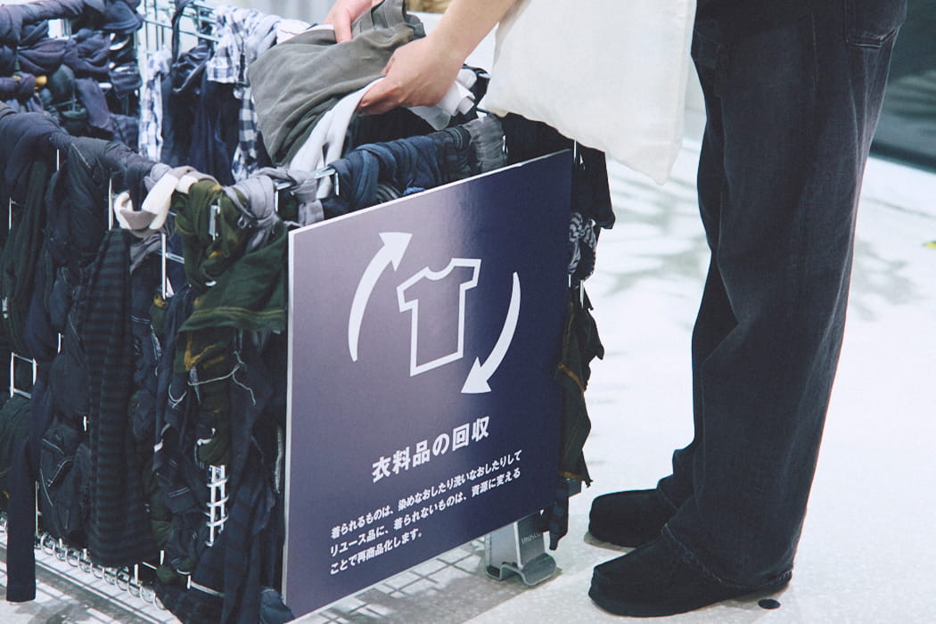 衣料品の回収BOXに衣服を入れている写真