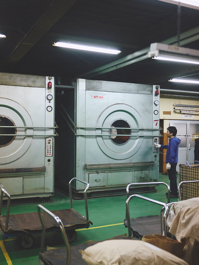 大型の事務用洗濯機で衣服を洗濯している写真