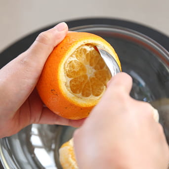 スプーンで果肉を取り除く様子