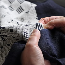 職人が複雑な幾何学模様を刺繍する手もとのようす