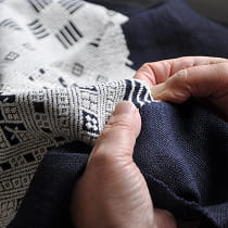 職人が複雑な幾何学模様を刺繍する手もとのようす