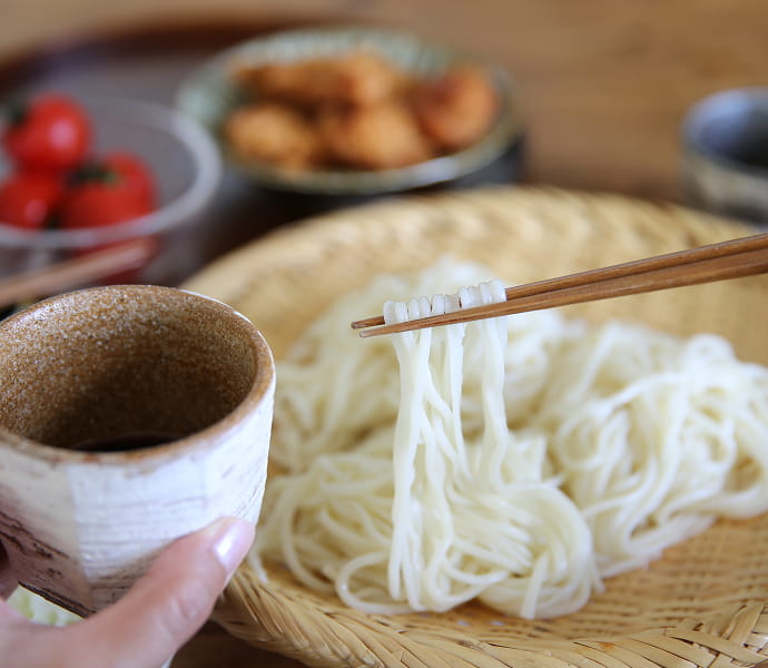 ざるに乗った「五島うどん」と「五島うどんがおいしくいただけるあごつゆ」のイメージ