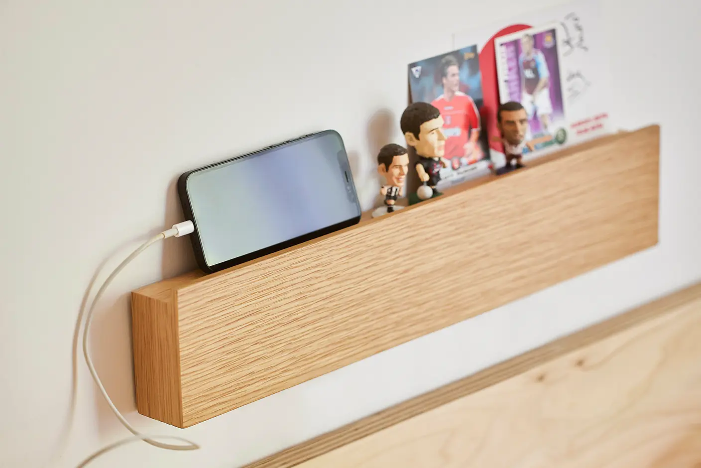 壁に付けられる家具長押にスマホやフィギュアを置いて使う様子。