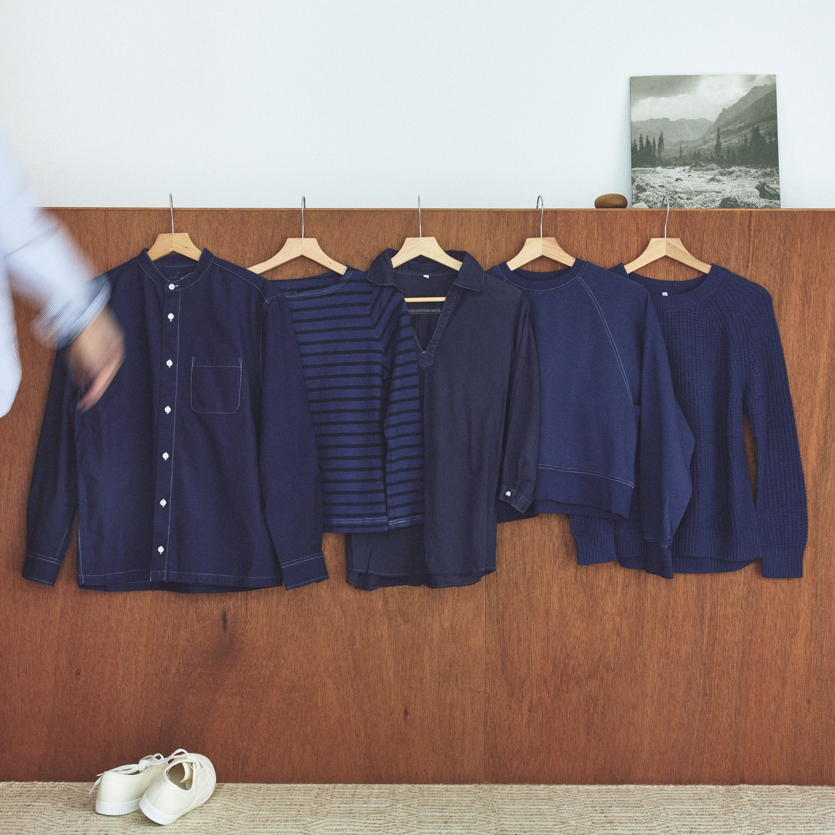 ハンガーにかけて並べたReMUJIの服。濃淡の異なる紺色が並びます。