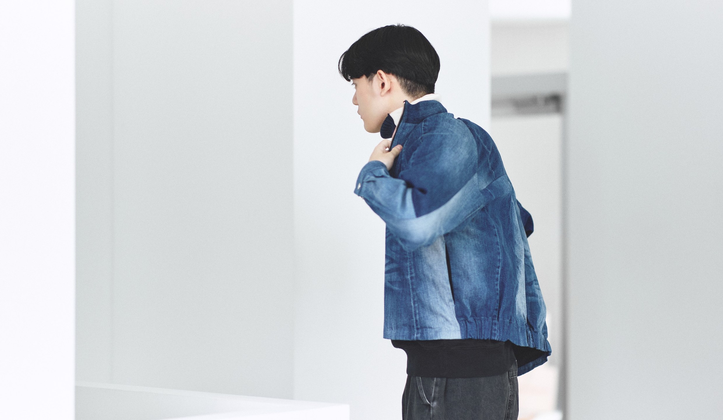 つながる服のデニムブルゾンを羽織った後ろ姿。