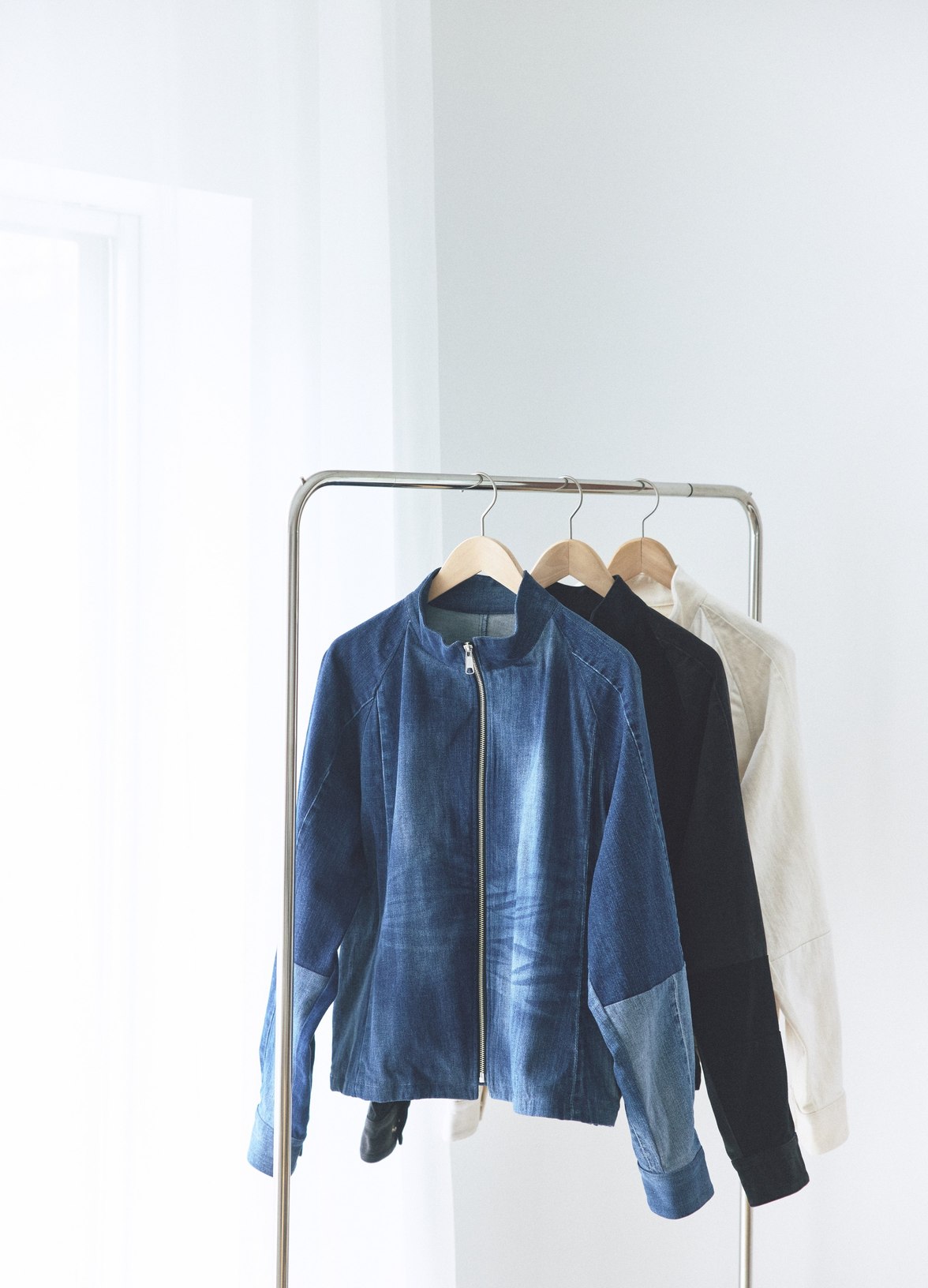 ラックにかけたつながる服のブルゾン。異なる布をつなぎ合わせた一点ものです。