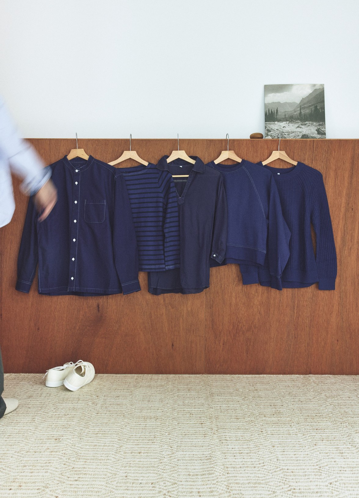 壁にかけて並べた染めなおした服。濃淡の異なる紺色が並びます。