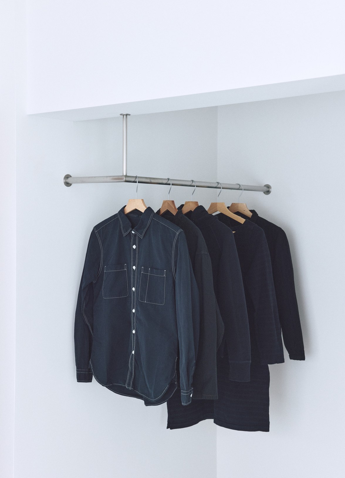 ハンガーラックにかけた、染めなおした服のシャツとカットソー。