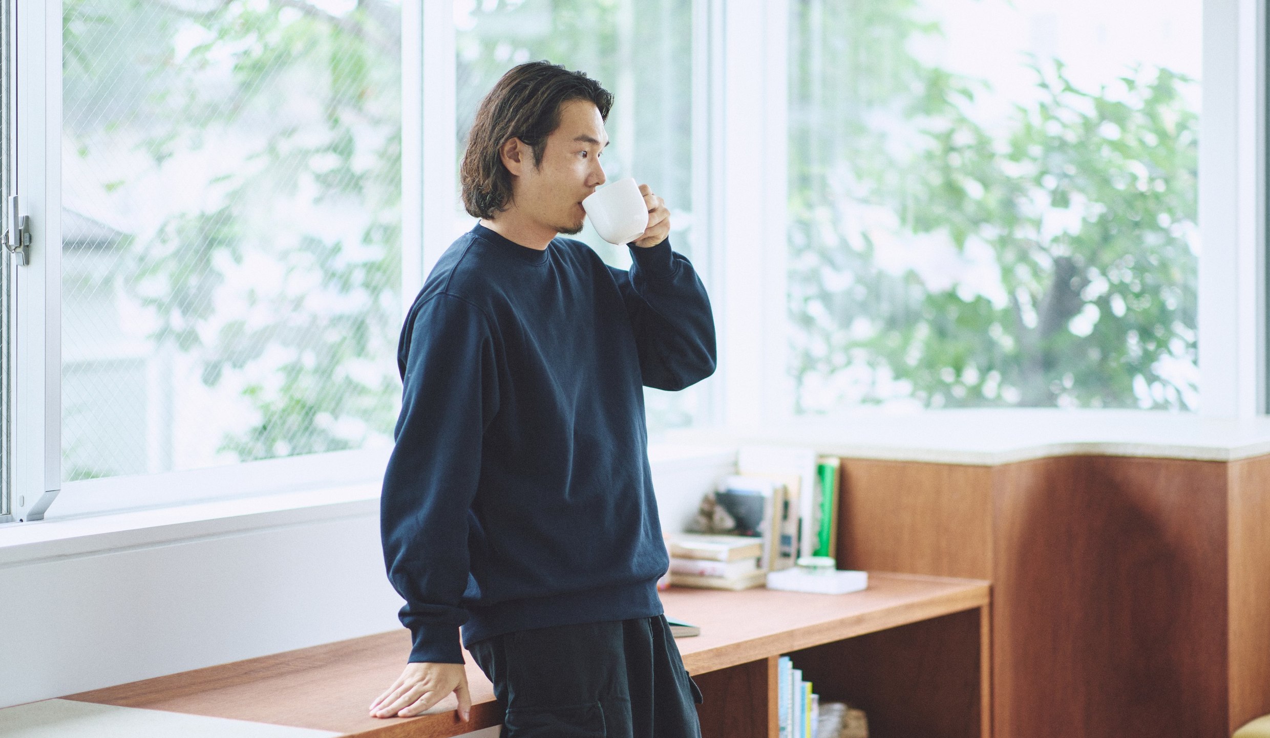 染めなおした服のトップスを着て、窓辺でひと息つくところ。