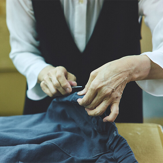染め上がった服を一点一点、検品。畳みながらポケットを整え、飛び出ている糸を切ります。