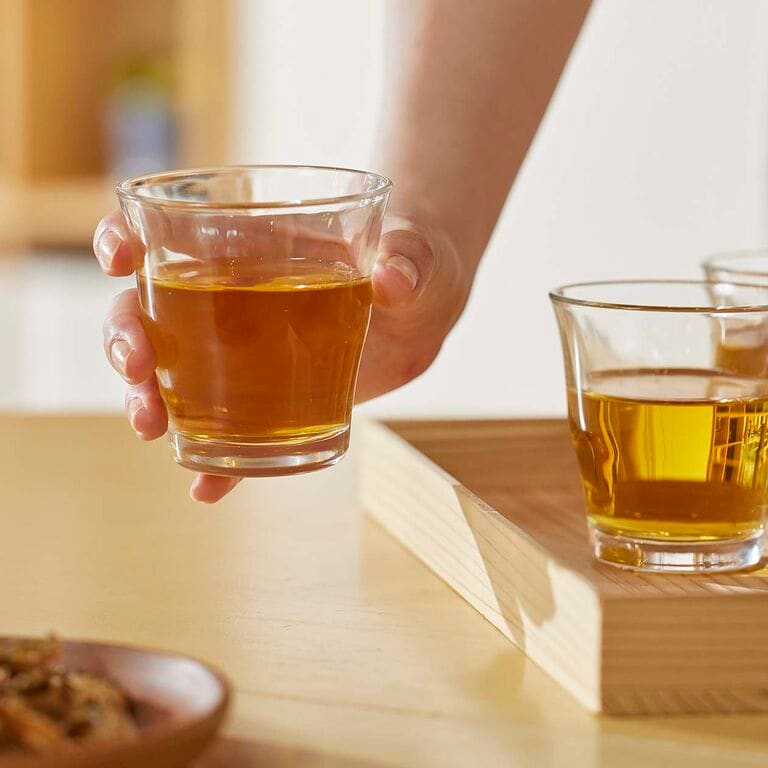 麦茶の入ったグラスを持つ手