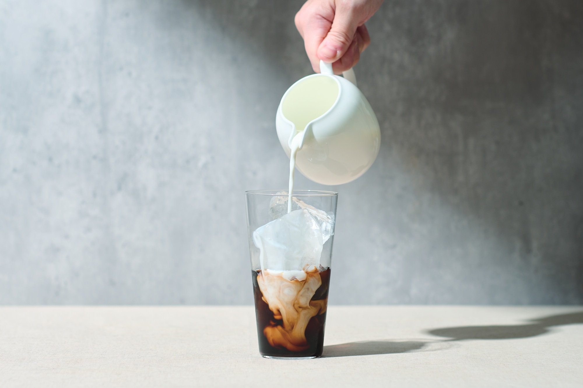 カフェオレベースに牛乳を注いでる画像