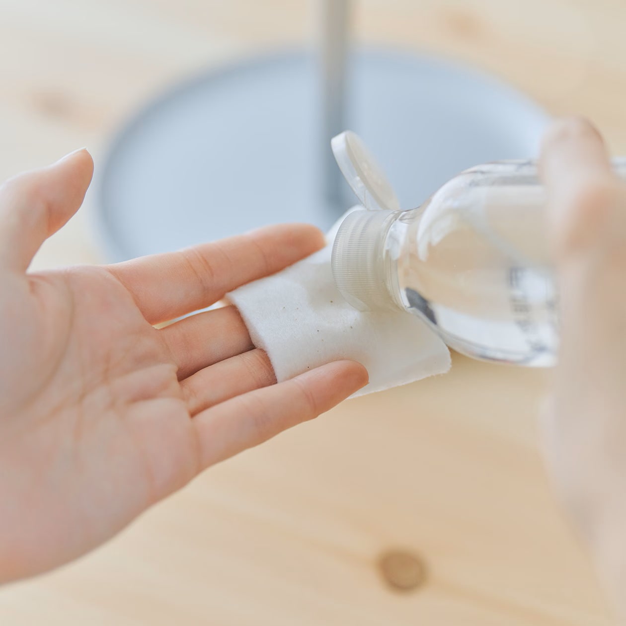化粧水をコットンにしみこませているところ