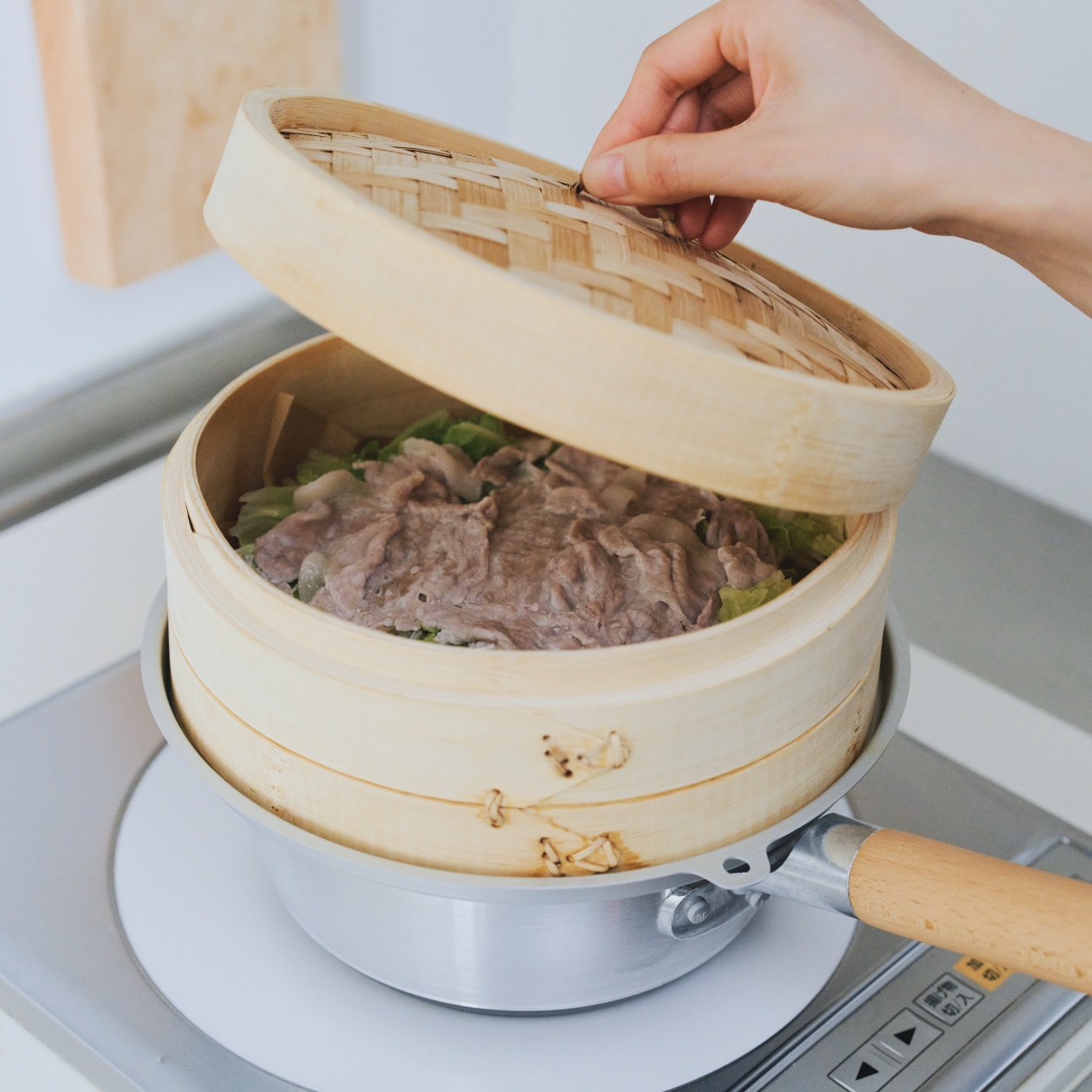 蒸篭のふたを開けかけている瞬間