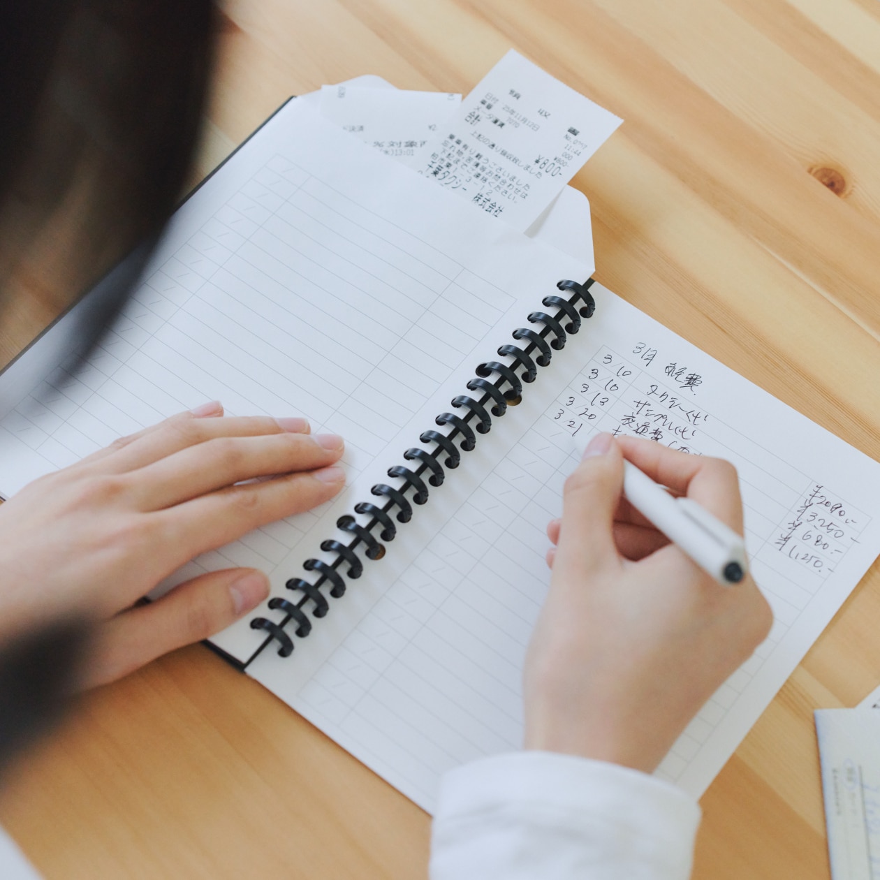 記録ができる家計簿封筒に書き込む女性