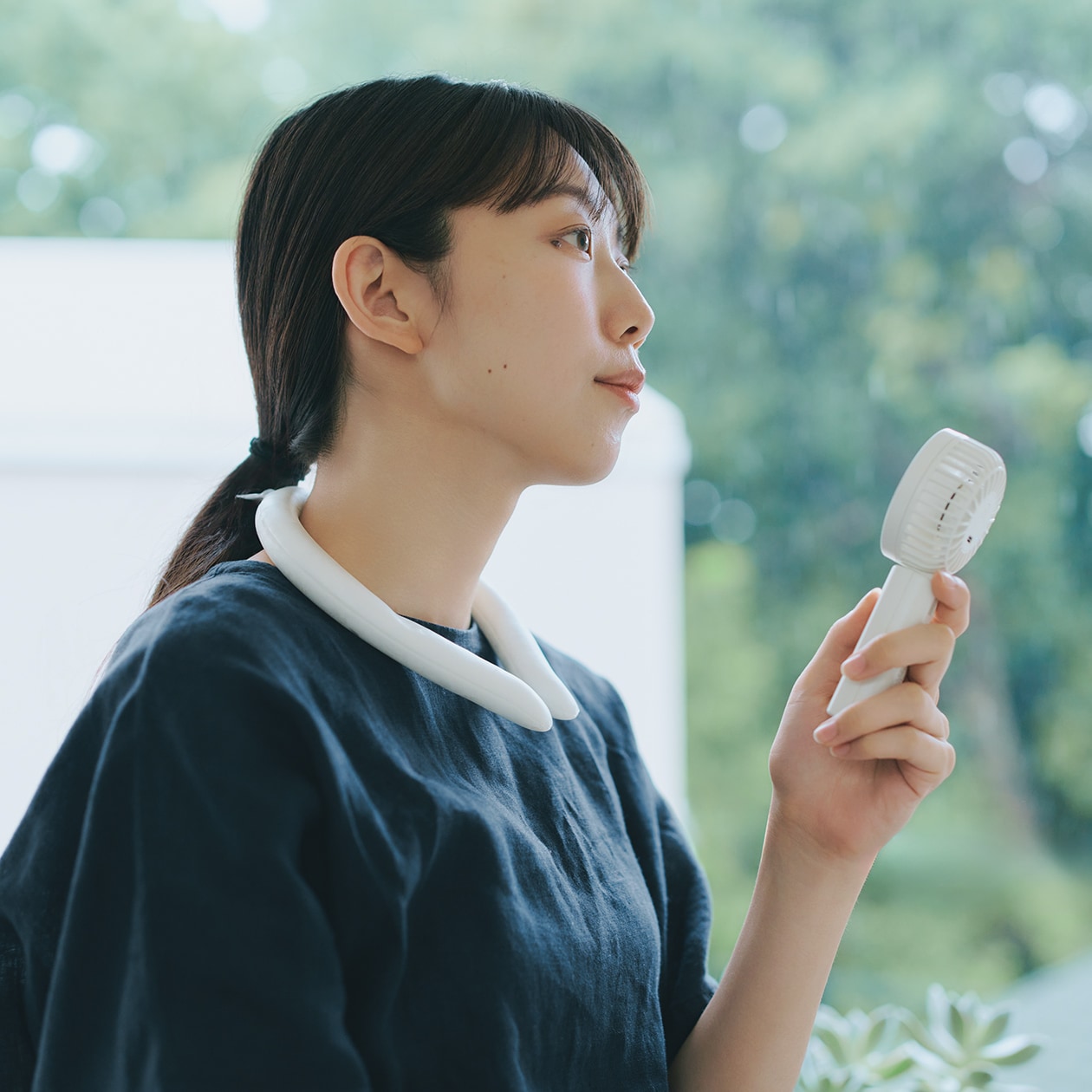 無印良品のハンディファンで涼む人