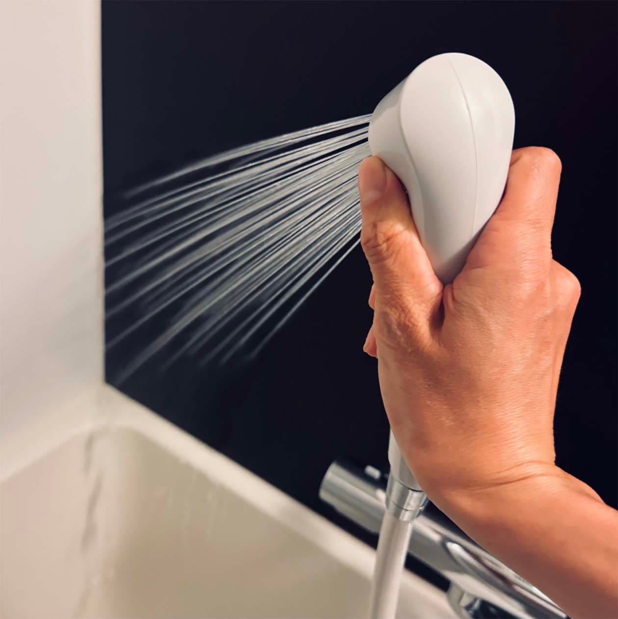 バスルームの壁面に、冷水シャワーをかけているところ