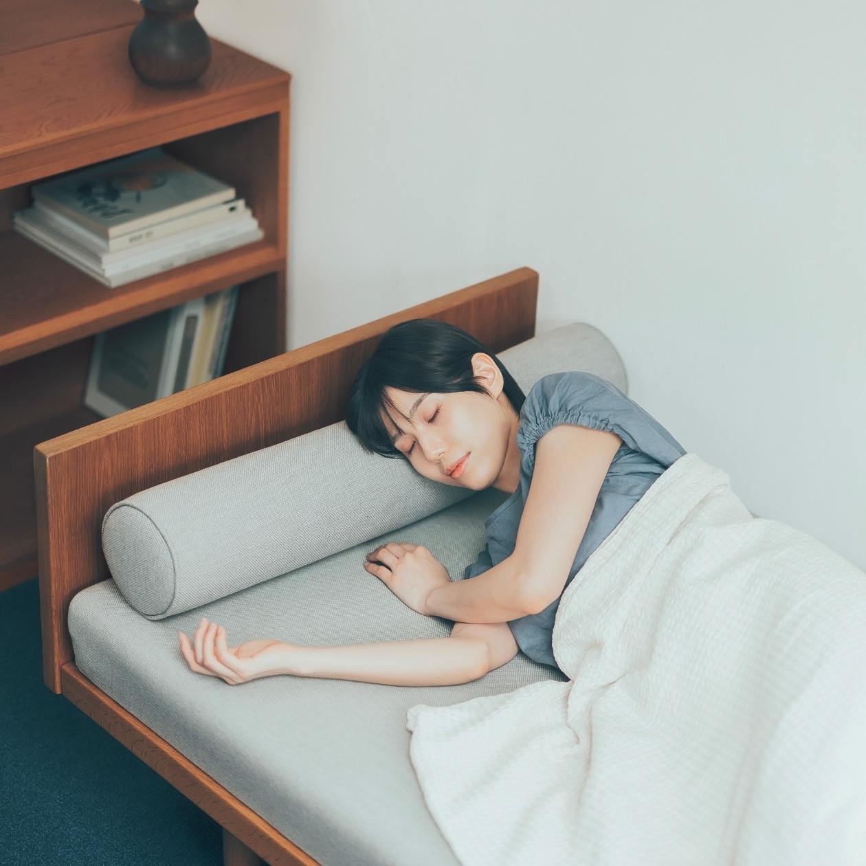 気象病の頭痛のケア ソファに横になる女性