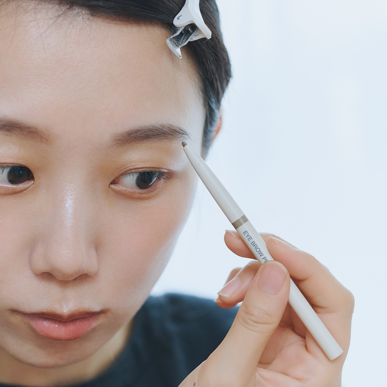 無印良品のアイブローペンシルを使う女性