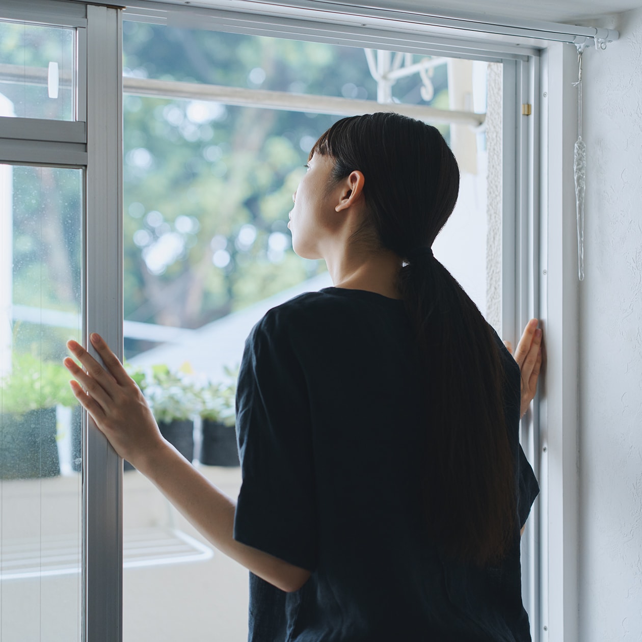 窓の外をのぞく女性