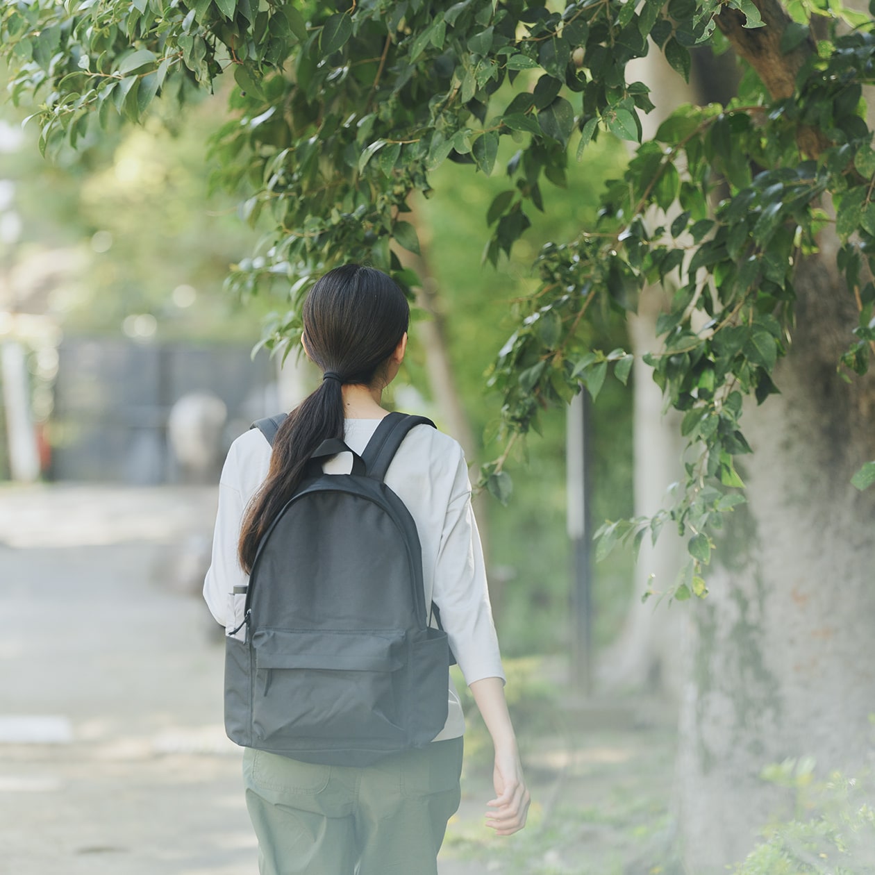 無印良品のリュックサックを担いで歩いている女性