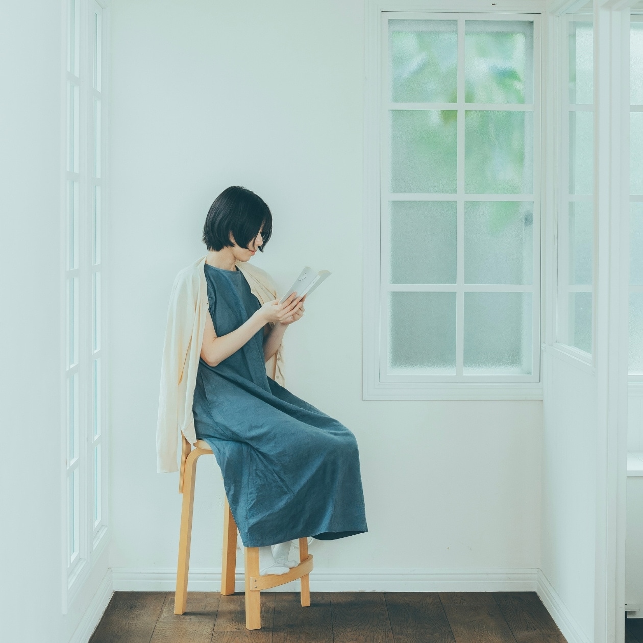雨の日に窓際で本を読む女性