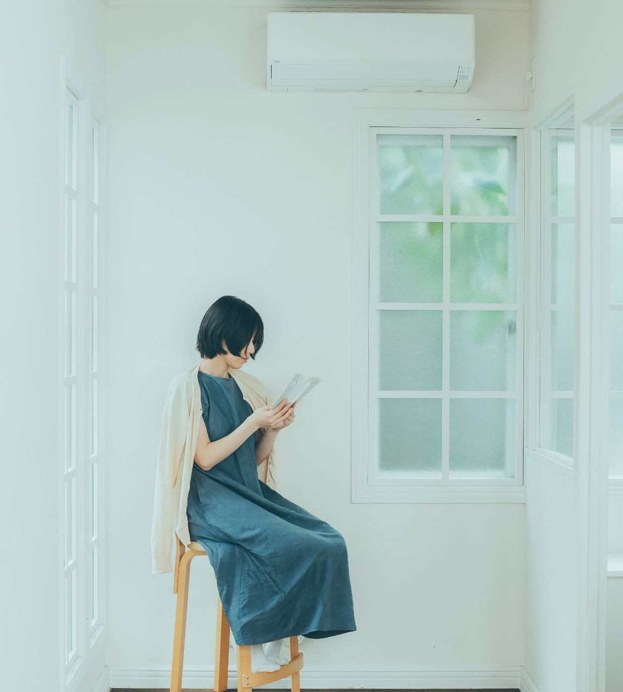 エアコンの効いた部屋で羽織を肩にかけて本を読む女性