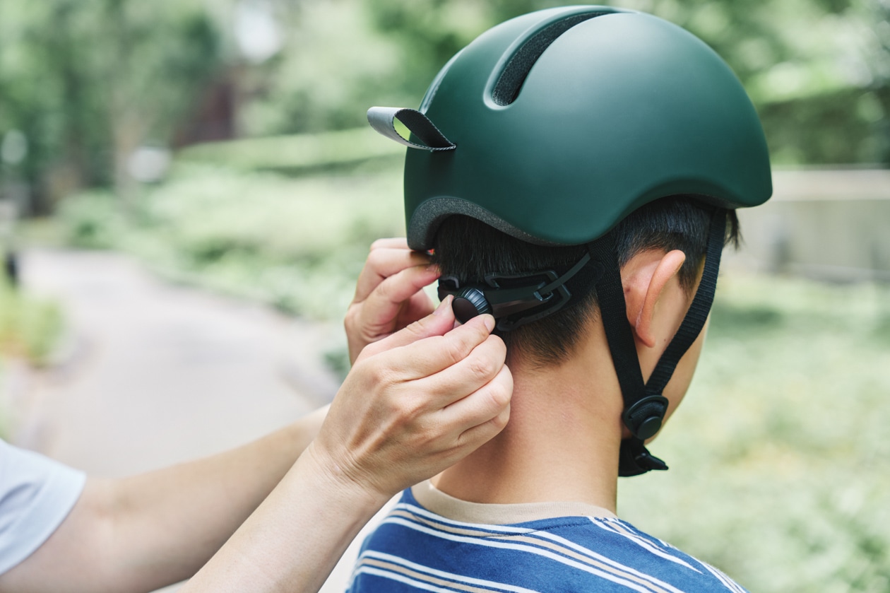 無印良品の風が抜ける自転車ヘルメットのサイズを後頭部のダイヤルアジャスターで調整する様子