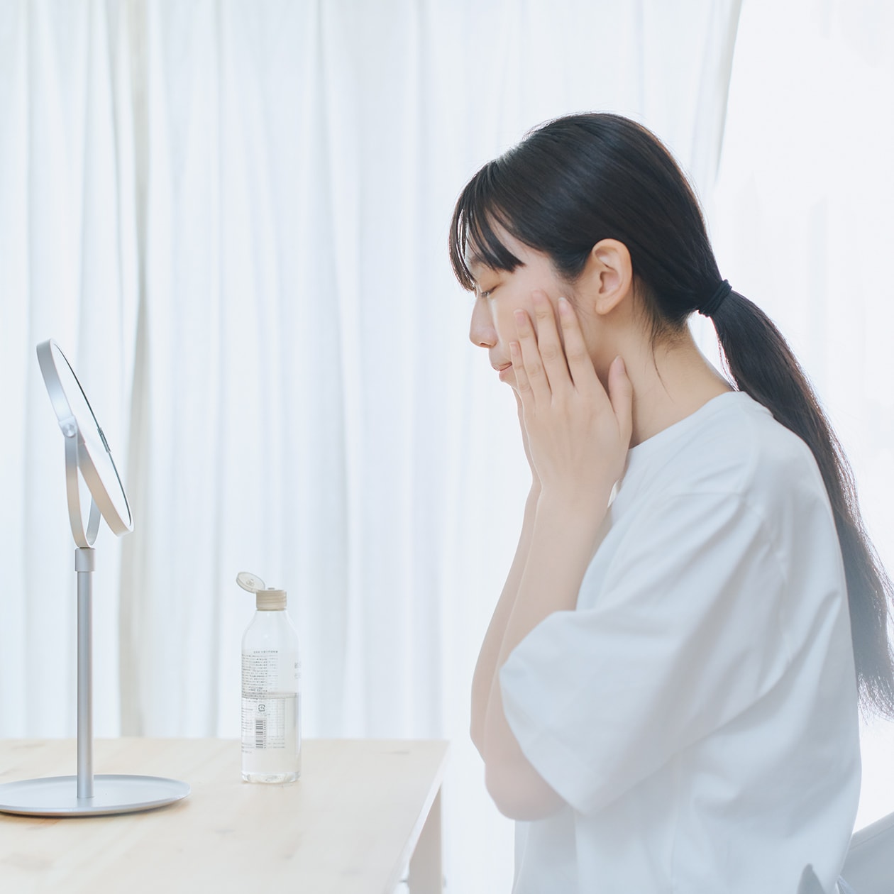 無印良品のスキンケア用品で手入れをしている人物