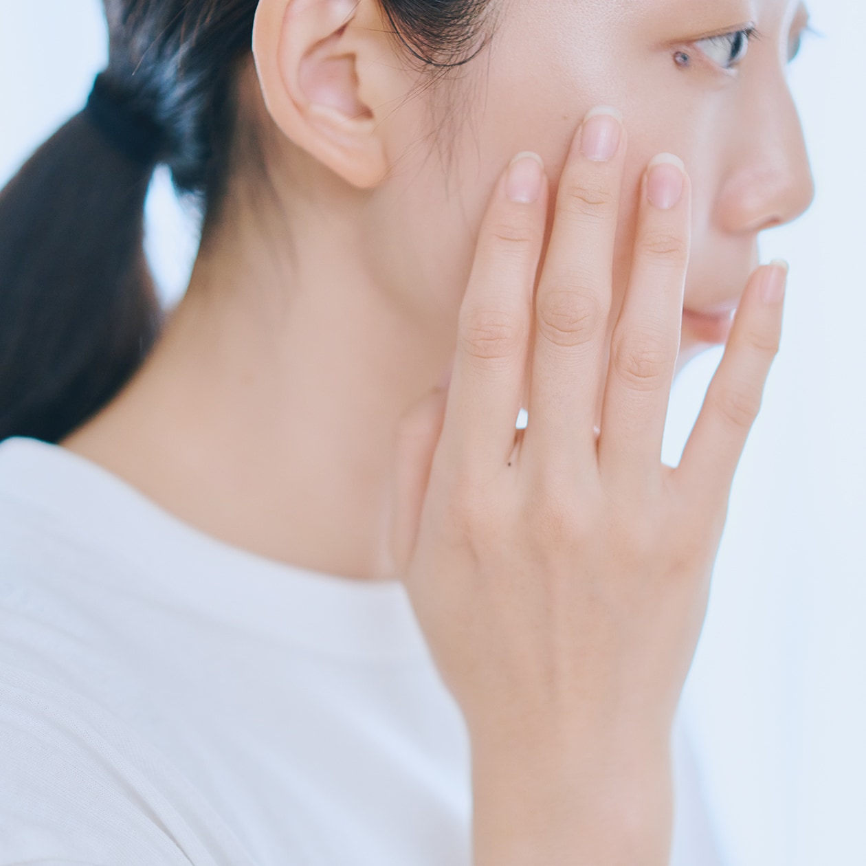 頬に触れている女性の横顔