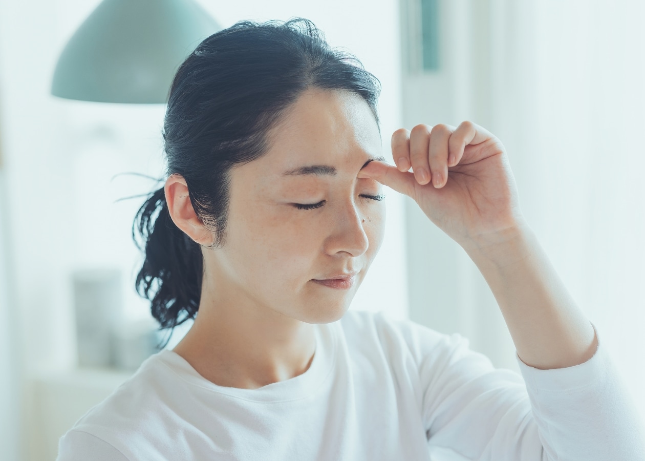 目頭のツボを押す女性