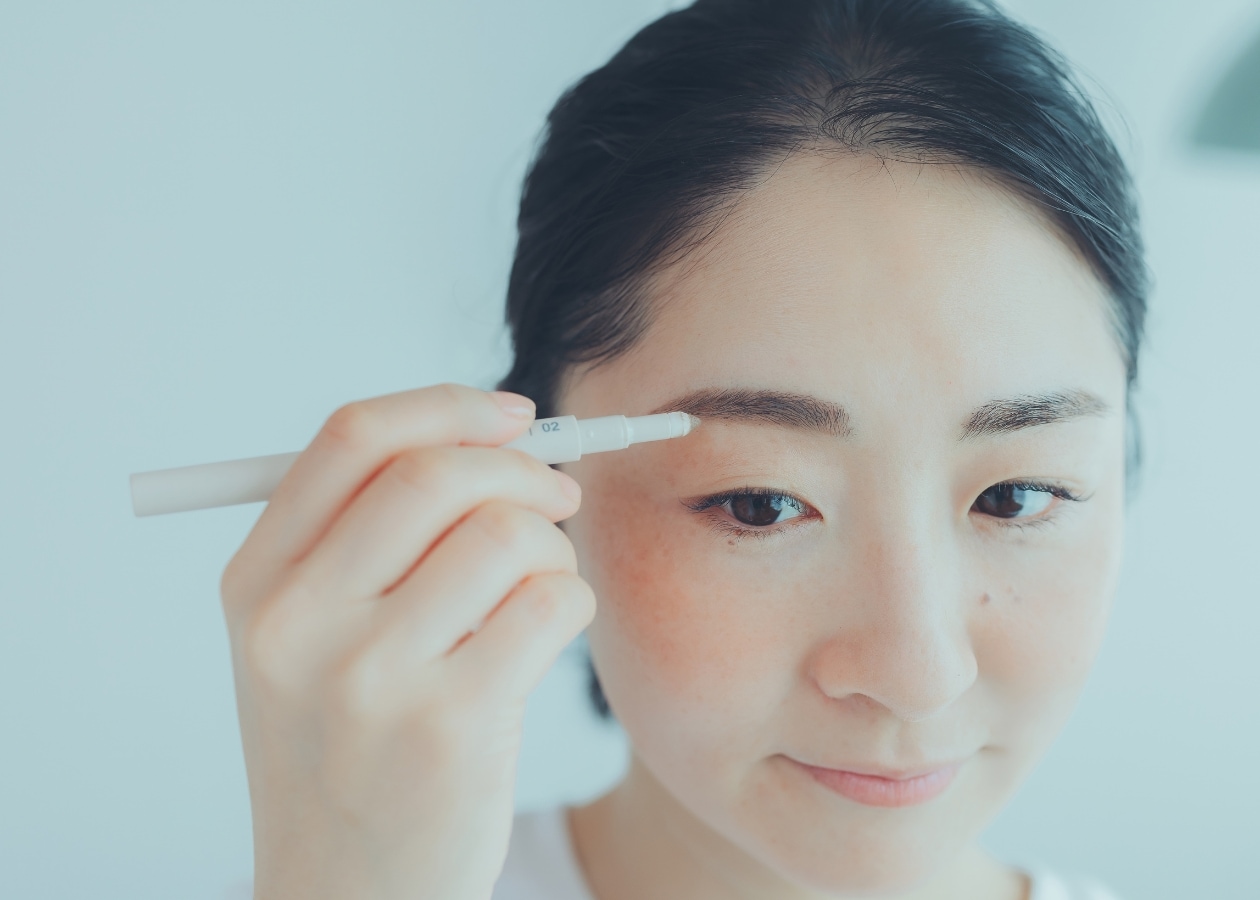 眉毛にパウダーをのせる女性