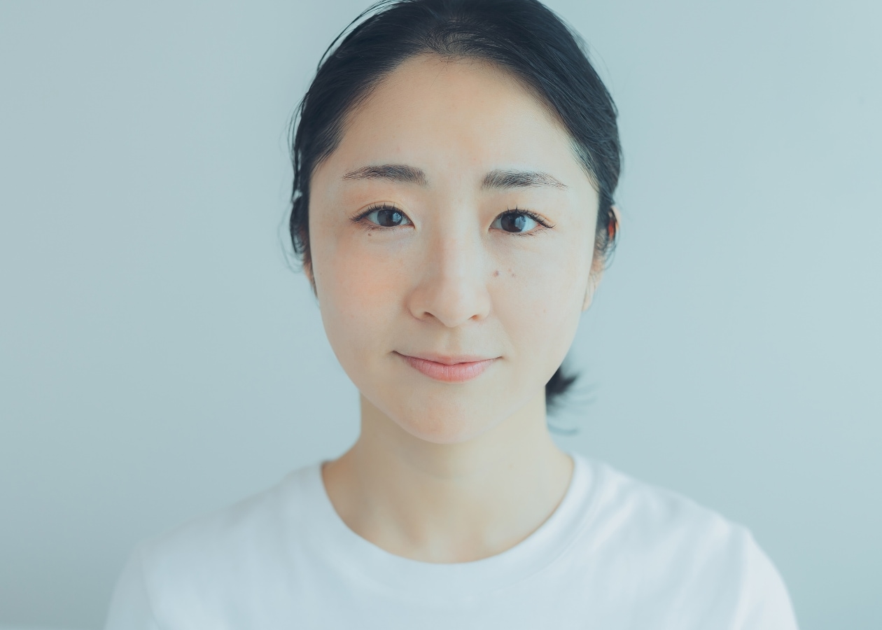 顔の半分だけクリームチークをのせた女性